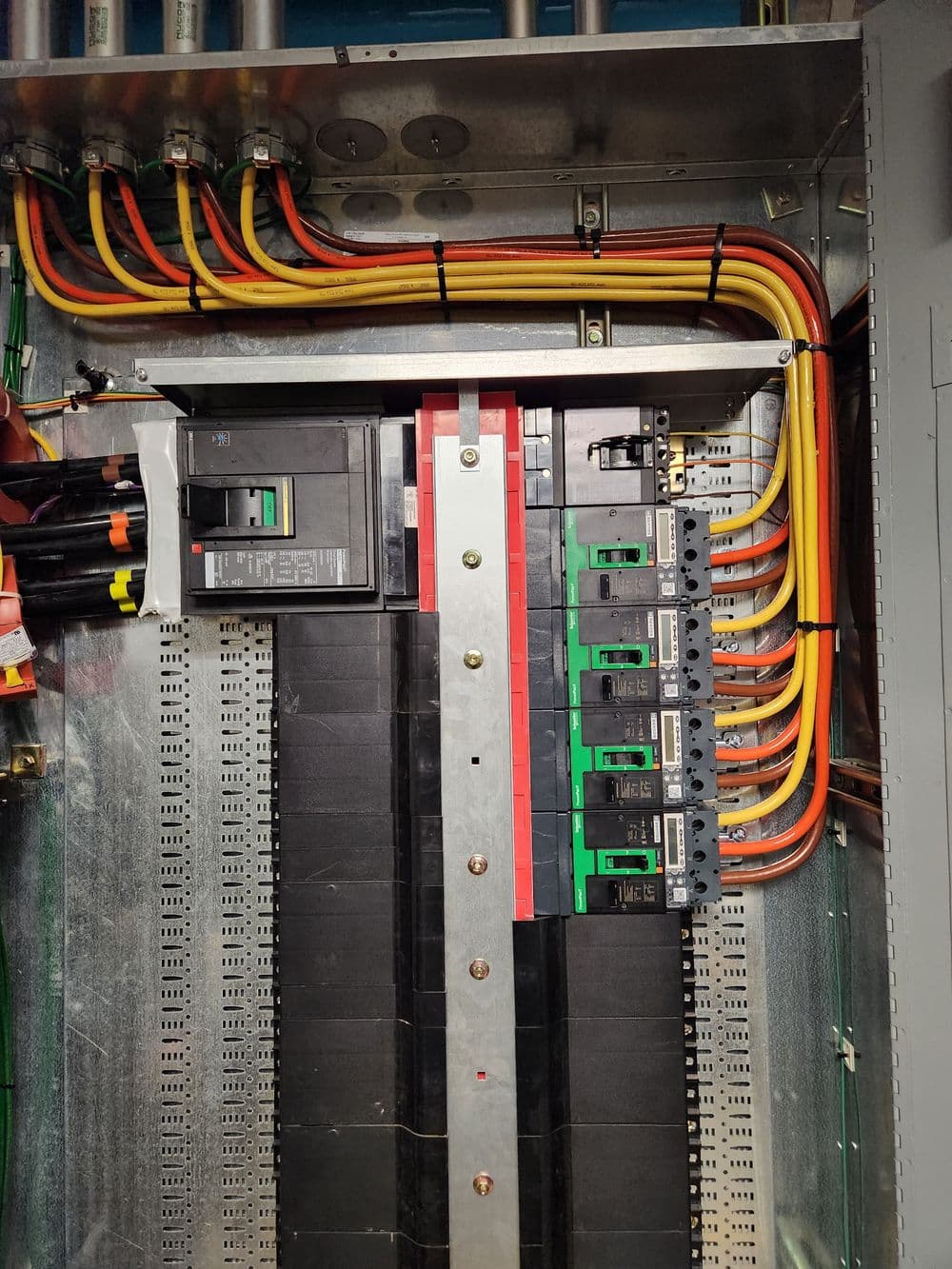 Electrical panel with circuit breakers, wires, and organized cable management.