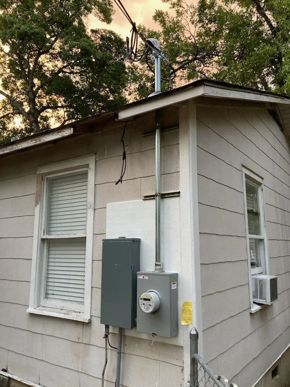 Electrical installation on a house, featuring a meter box and antenna on the exterior.