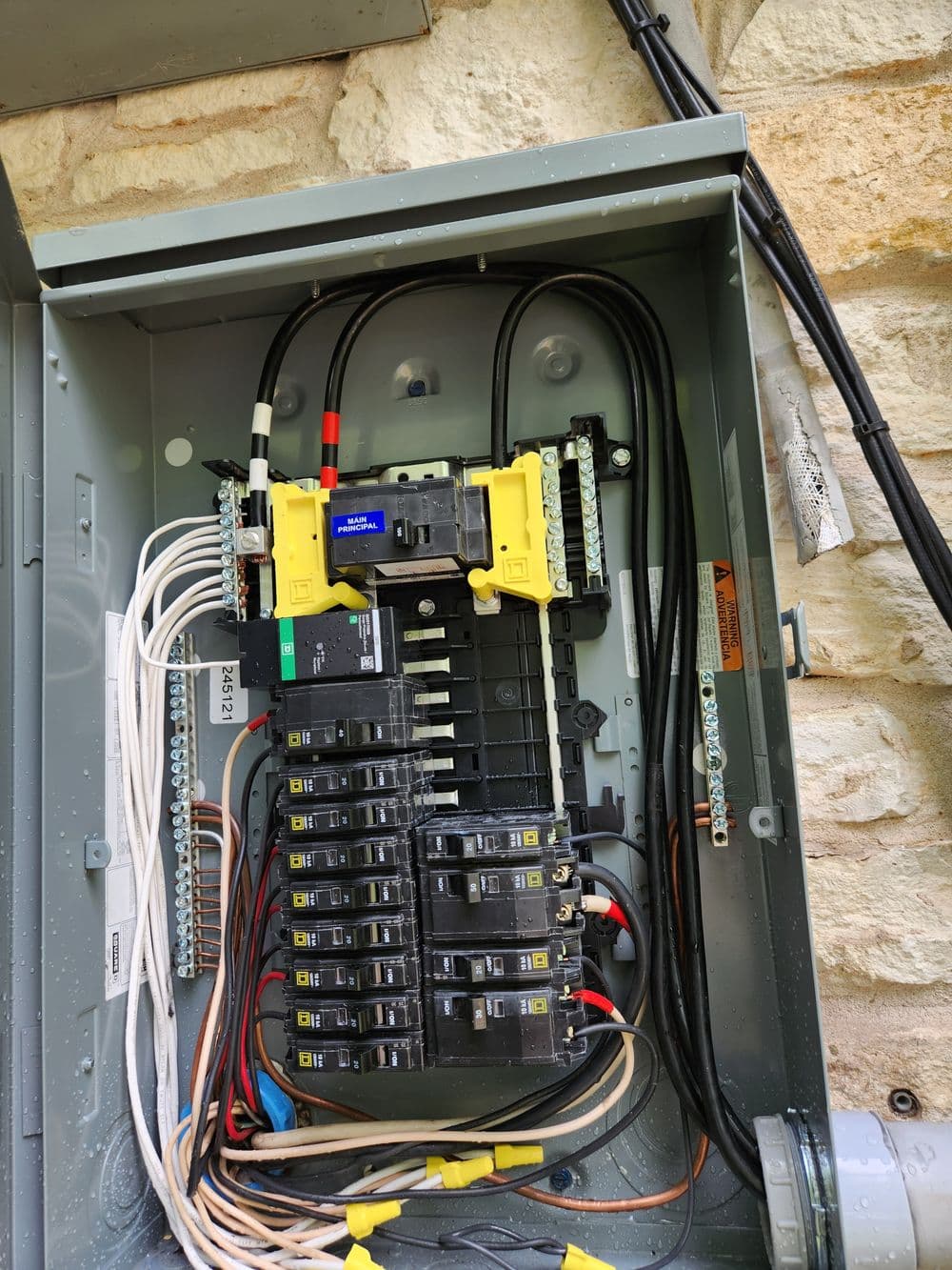 Electrical panel with circuit breakers and wiring for residential power distribution.