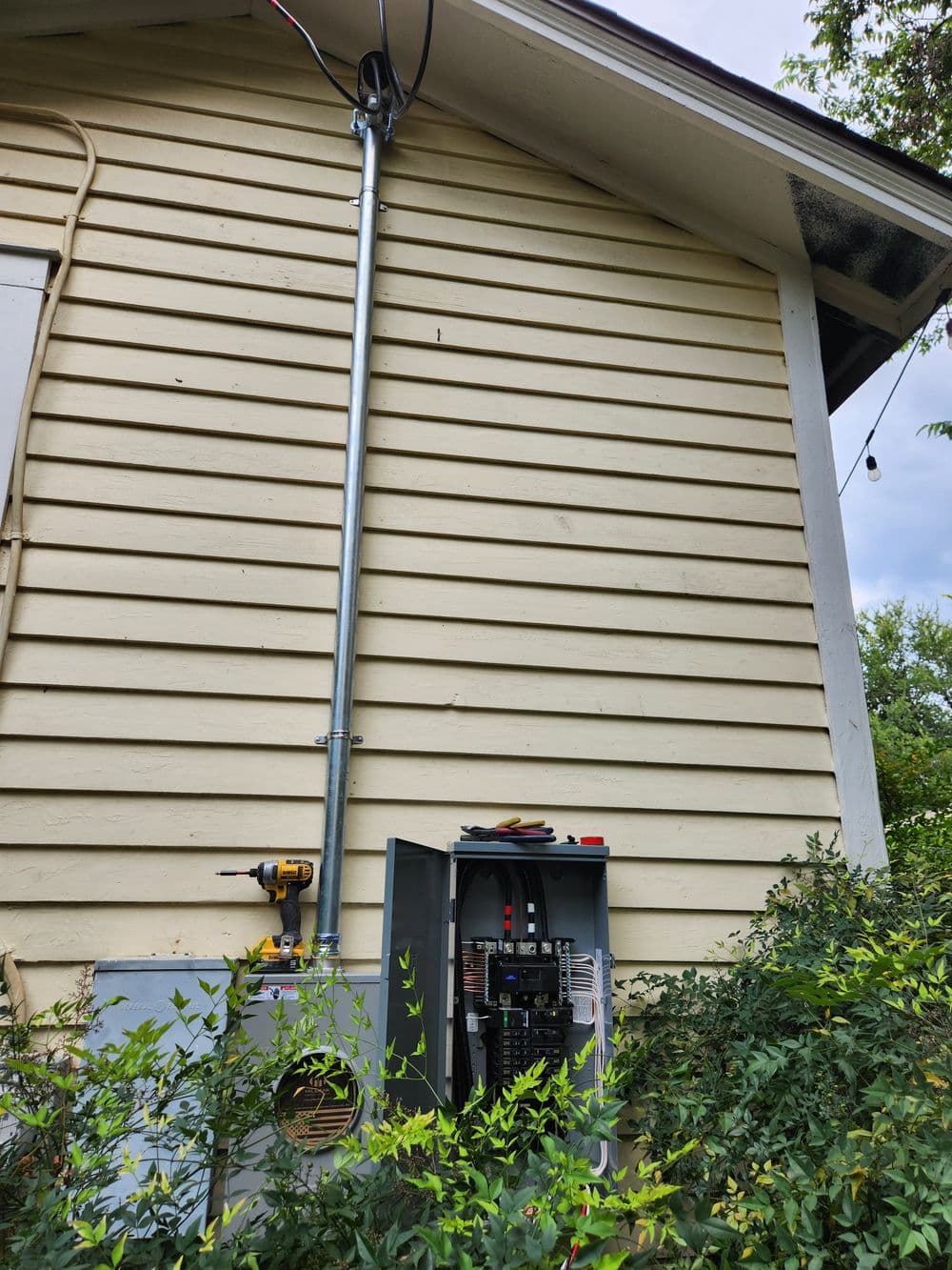 Exterior view of a house showing a power panel and antenna installation on the wall.