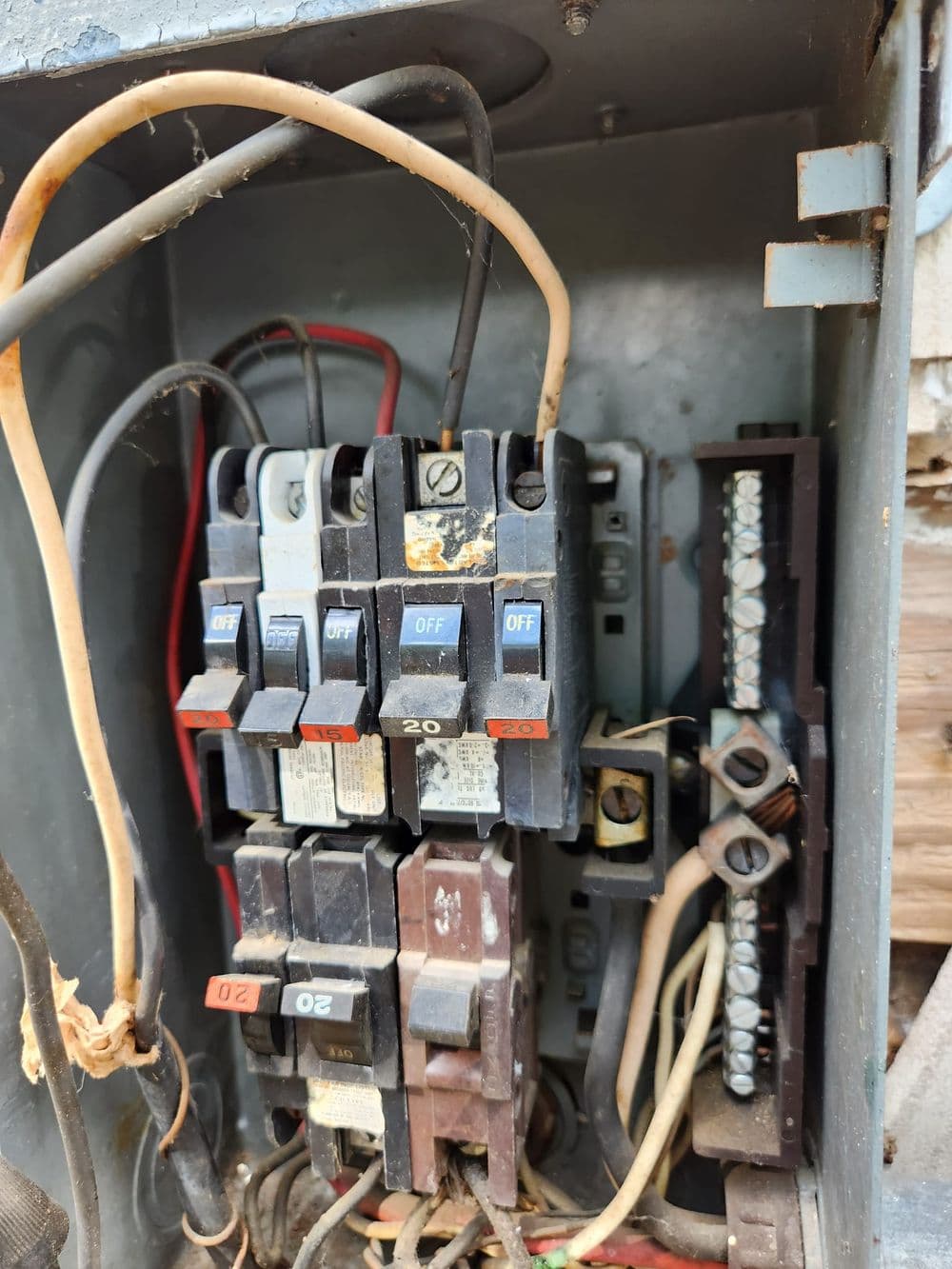 Circuit breaker panel with multiple switches and wiring, showing electrical components.